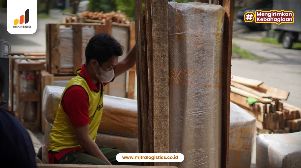 tim pindahan sedang packing barang dengan kayu